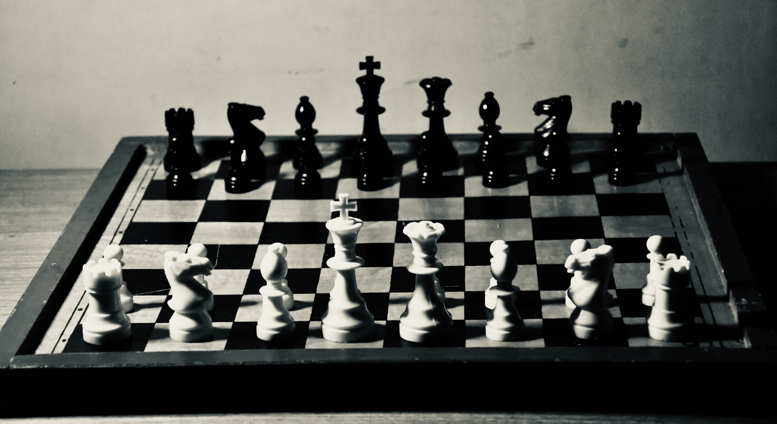 Black and white chessboard with opposing pieces facing off – symbolising the competitive mindset and the misconception of ‘winning’ in therapy