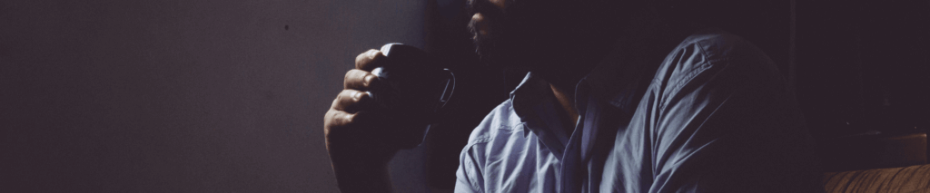 A man drinks a cup of coffee alone