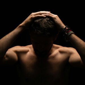 A man with his head in his hands, showing he's struggling with some feelings.