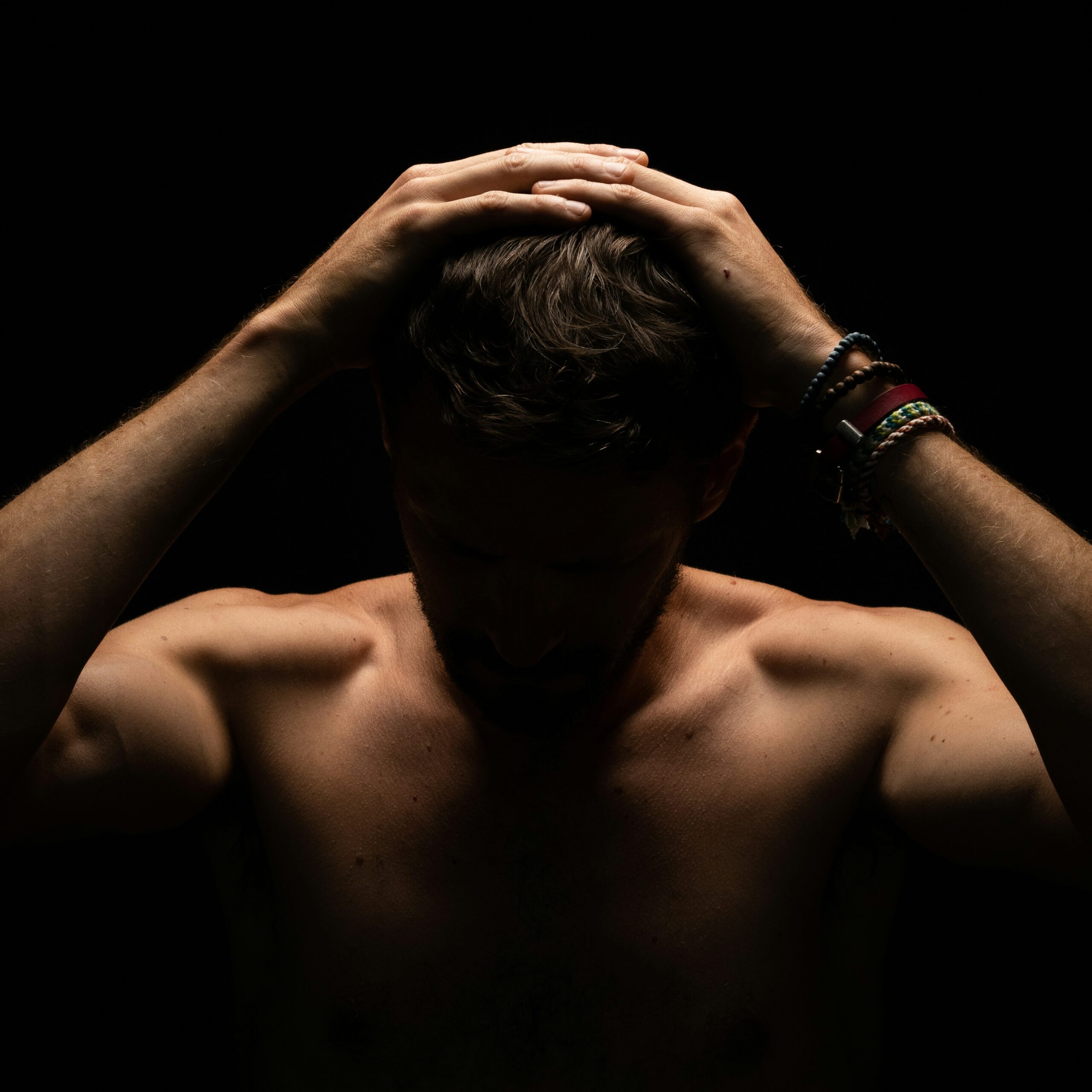 A man with his head in his hands, showing he's struggling with some feelings.