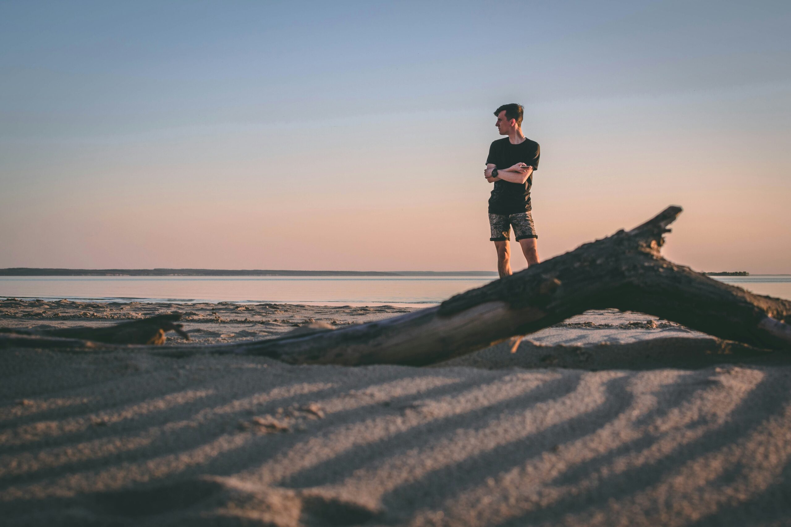 A man standing alone on a beach, representing the isolation and challenges showing feelings.