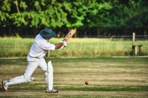 A cricketer, opening the batting to symbolise the impact of sport on self-regulation