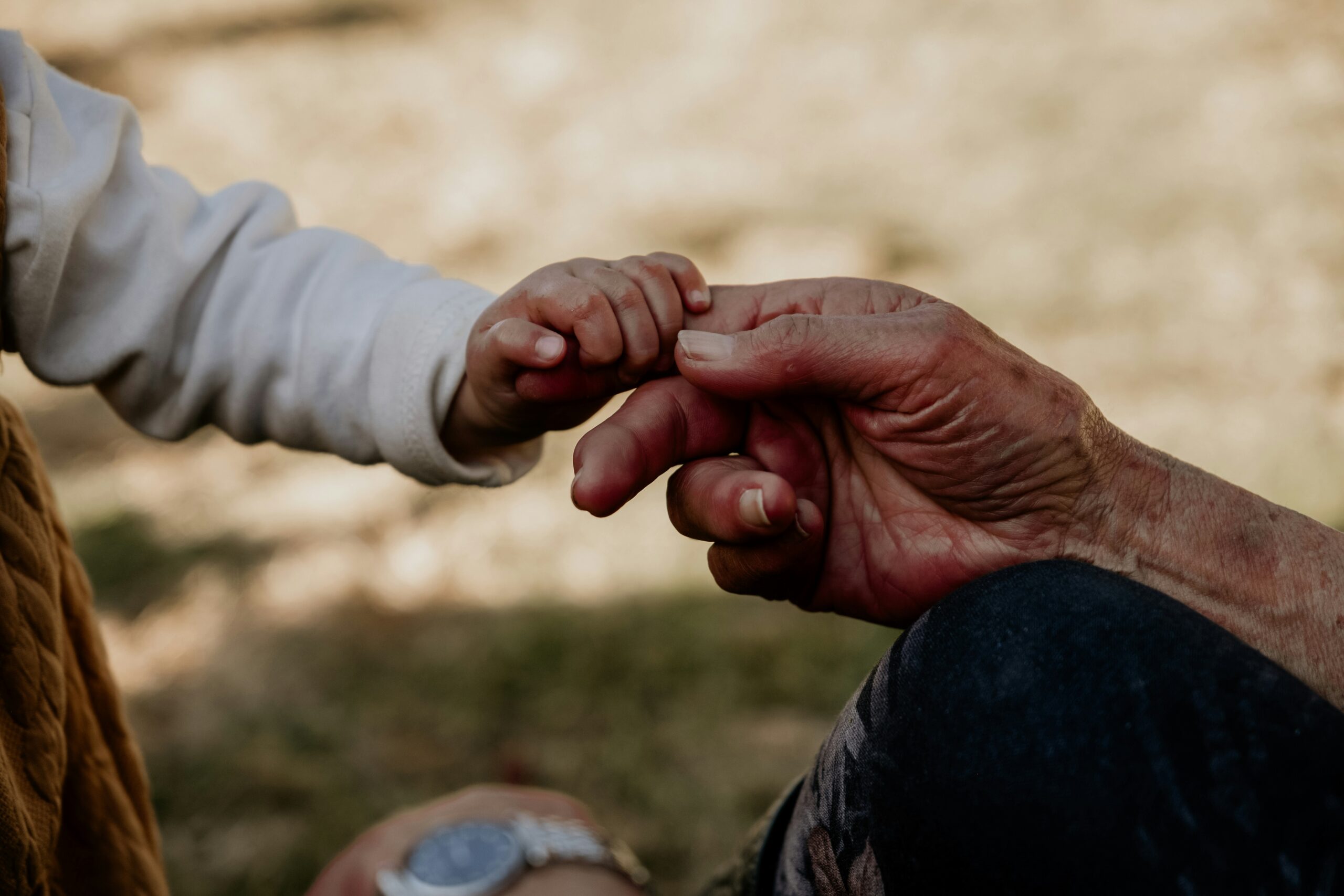 A child and adult hand, reaching for each other. Signifying attachment.