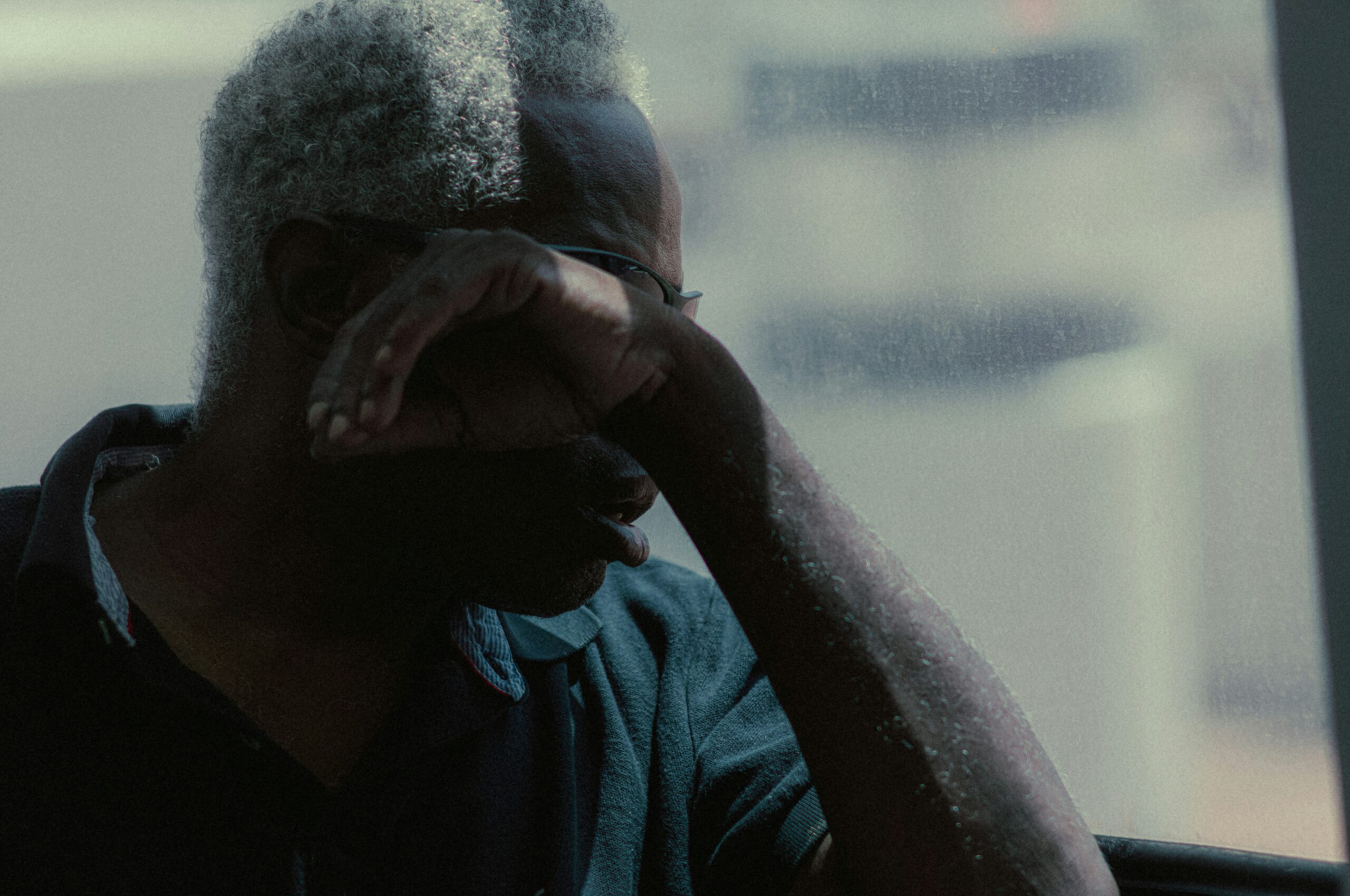 A man covering his face, symbolising the struggle to be seen as vulnerable.